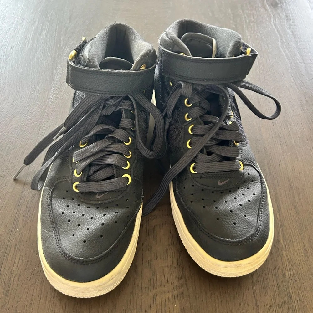 Nike Air Force ones black high top sneakers gold trim